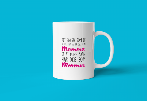 mamma og mormor - verdens beste mamma-kopp. En hvit keramikk-kopp med tekst "Det eneste som er bedre enn å ha deg som mamma er at mine barn har deg som mormor". Turkis bakgrunn