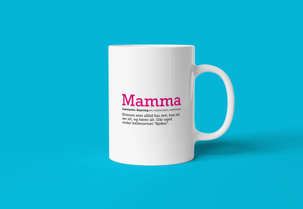 Definisjon på verdens beste mamma - En hvit keramikk-kopp med tekst som gir definisjonen på ordet mamma. Turkis bakgrunn